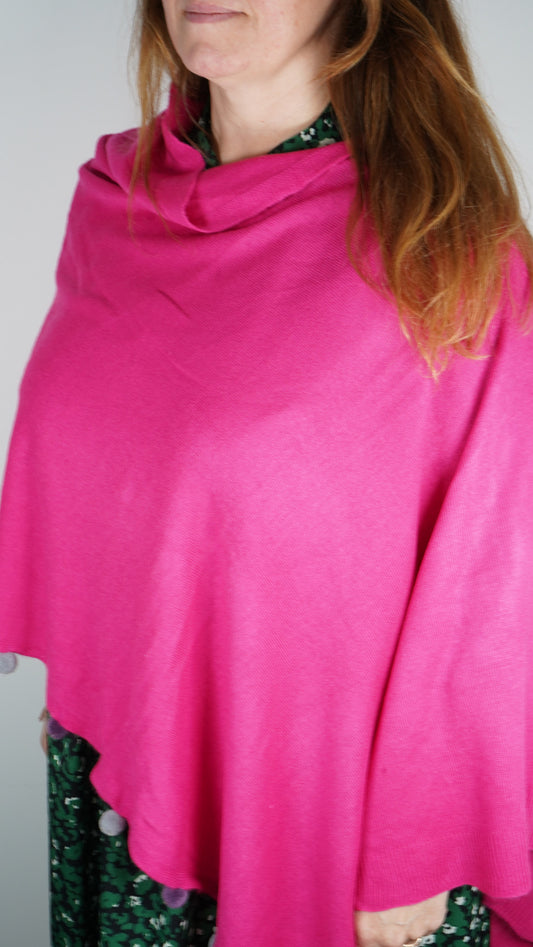 Pom pom edge poncho in fuchsia.